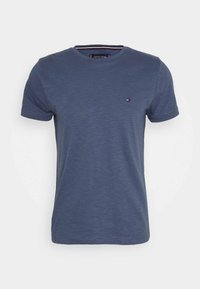 Lyhythihainen tummansininen pyöreäkauluksinen t-paita, jossa on pieni Tommy Hilfiger -logo vasemmassa rinnassa, esitetty valkoisella taustalla.