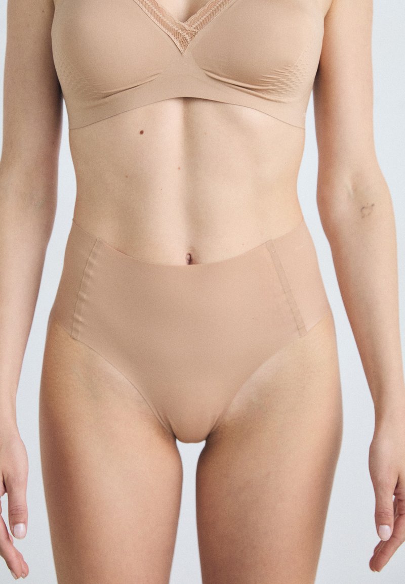 Nude bralette and high-waisted briefs in smooth, stretchy fabric. Simple design with subtle texture accents and clean seams.