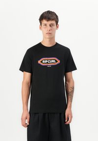 Svart bomull t-skjorte med en fargerik "RIPCURL" logo med oransje, lilla og gule detaljer. Korte ermer og rund hals.