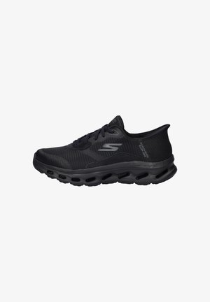 Scarpa sportiva nera con tomaia in mesh, punta arrotondata e suola ammortizzata. Caratterizzata da un design con lacci e dettagli testurizzati sui lati.