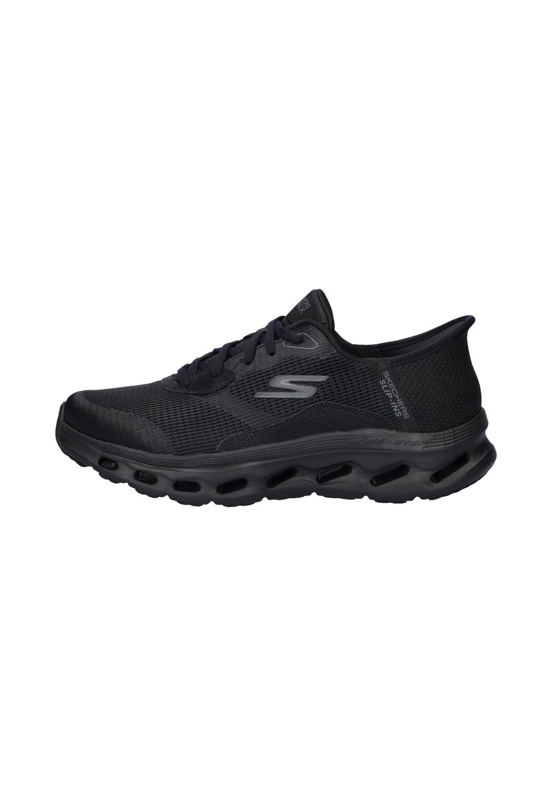 Scarpa sportiva nera con tomaia in mesh, punta arrotondata e suola ammortizzata. Caratterizzata da un design con lacci e dettagli testurizzati sui lati.
