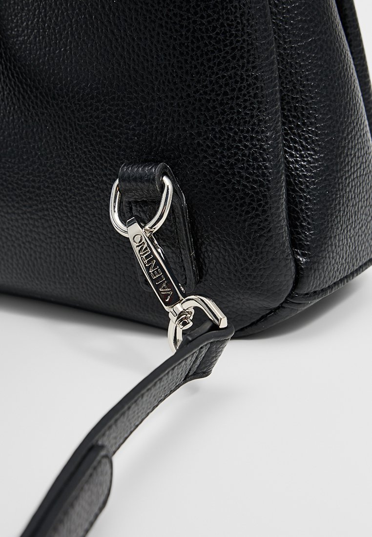 Schwarze Lederhandtasche mit strukturiertem Finish, ausgestattet mit einem silbernen Verschluss und einem strapazierfähigen Tragegurt. Kompakte, eckige Form.
