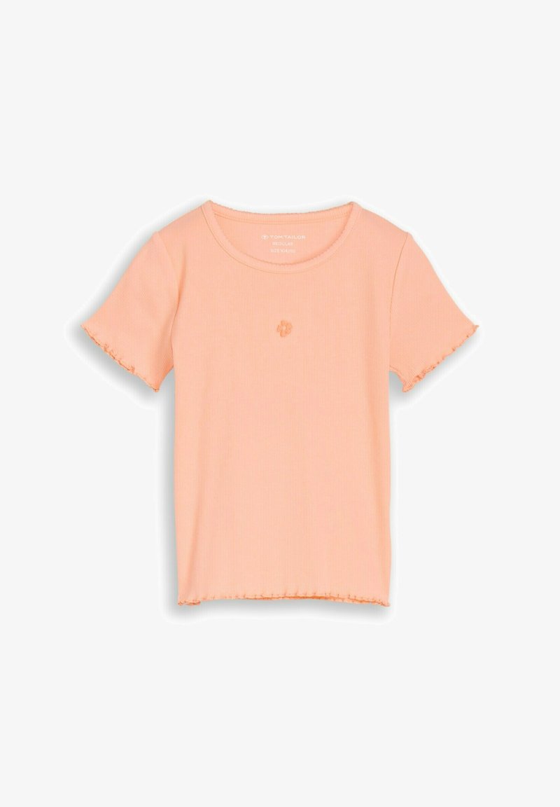 T-shirt à manches courtes, couleur pêche, en tissu côtelé avec bordure frisée sur les manches et l'ourlet, et petit détail de fleur brodée au centre de la poitrine.