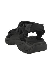 Mustat ulkoilusandaalit, joissa on säädettävät hihnat, teksturoitu pohja, kestävä kumipohja ja kohotettu pito-ominaisuus.