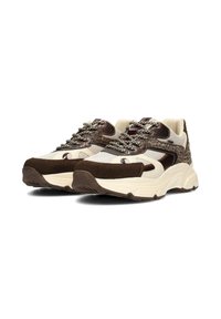 Sneakers con una toma in rete crema, accenti in suede marrone e lacci testurizzati. Presentano una suola bianca spessa e un dettaglio di design unico sui lati.