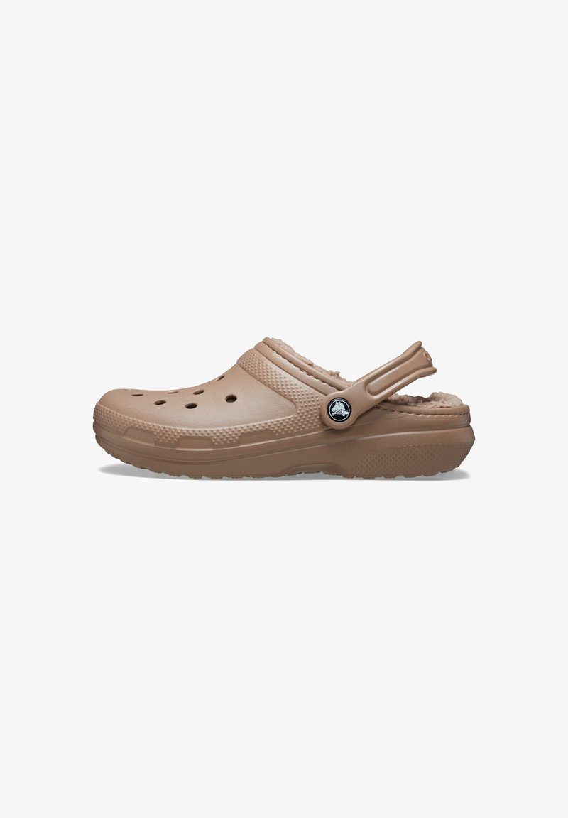 Sabot en mousse marron avec une doublure douce en polaire, des trous de ventilation et une sangle arrière pour un maintien sécurisé ; accents texturés sur le côté.