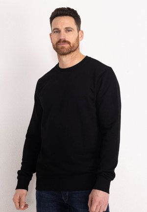 Sweatshirt noir à col rond avec des manches longues, des poignets côtelés et une taille côtelée. Fabriqué en tissu lisse et léger, idéal pour superposer.