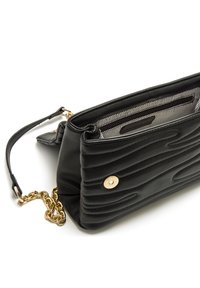 Clutch in pelle nera con texture trapuntata, dettaglio catena dorata e bottone a scatto circolare. Interno con fodera a righe e scomparti.