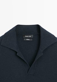 Granatowy wełniany sweter polo z prążkowanym kołnierzem i plisą. Metka oznaczona „Massimo Dutti” oraz „100% wełna.” Miękka faktura, klasyczny krój.
