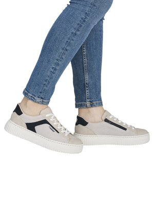 Beige and black sneakers made of mesh and suede with a thick white sole, featuring lace-up closure and a zip detail on the side.