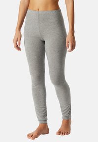 Grijze leggings gemaakt van zachte, rekbare stof, met een hoge tailleband en een gladde, aansluitende pasvorm die de benen contouren.
