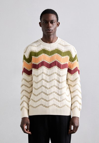 Sweter dzianinowy w kolorze kremowym z wzorem w zygzaki w kolorze zielonym, pomarańczowym i burgundowym. Włóczka o fakturze z prążkowanymi mankietami i dołem, z okrągłym dekoltem.