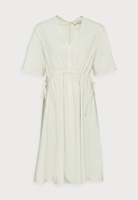 Vaaleanvihreä puuvillamekko, jossa on V-pääntie, lyhyet hihat, joustava vyötärö ja nauhakuja, jossa on virtaava hame ja minimalistinen muotoilu.