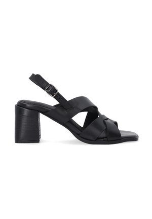 Schwarze Leder-High-Heel-Sandalen mit einem Blockabsatz, die über gekreuzte Riemen und einen verstellbaren Knöchelriemen verfügen. Glatte Textur und minimalistisches Design.