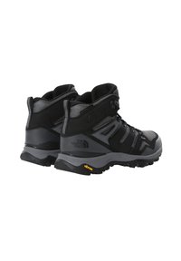 Czarne buty trekkingowe z oddychającą siateczką, wzmocnionymi zamszowymi akcentami i podeszwami Vibram zapewniającymi przyczepność. Średni krój oferuje wsparcie kostki.