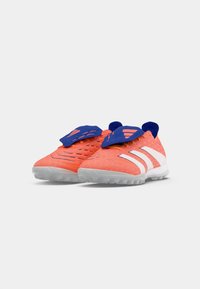Zapatillas deportivas de color naranja brillante con detalles en azul, parte superior texturizada, rayas blancas y una suela de goma curva diseñada para tracción.