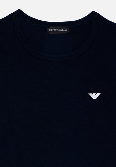 Zwart T-shirt met ronde hals en wit Emporio Armani arendlogo geborduurd op de linkerborst, met een zwart merkembleem aan de binnenkant van de kraag.