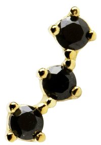 Gioiello in oro con tre pietre nere sfaccettate, ciascuna incastonata in un design a griffe, disposte in una leggera curva.