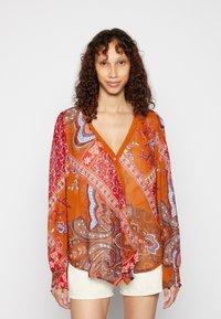 Blusa de manga longa, decote em V, na cor laranja, com padrões paisley e florais. Tecido leve com punhos franzidos e design em camadas.