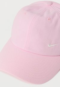 Ružová šiltovka s textúrovanou tkaninou. Má prešité detaily a malý biely logo Nike na prednej strane.