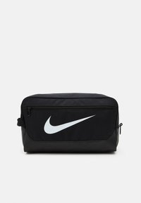 Black Nike toiletry bag with a smooth texture, featuring a white swoosh logo, top zip closure, and a side pocket.