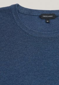 Granatowy, dziany sweter z prążkowanym okrągłym dekoltem oraz metką z napisem "PROCHNIK" w rozmiarze "M". Gładka faktura z subtelnym wzorem.