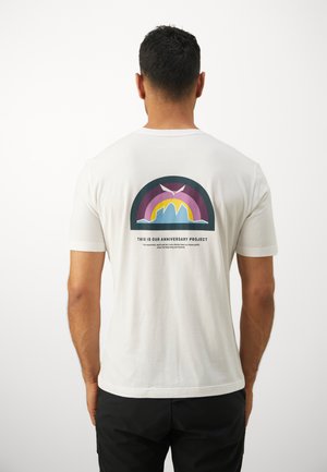 Weißes Baumwoll-T-Shirt mit einem bunten Grafikdesign auf der Rückseite, das ein stilisiertes Berg- und Regenbogenmotiv mit Text darunter zeigt.