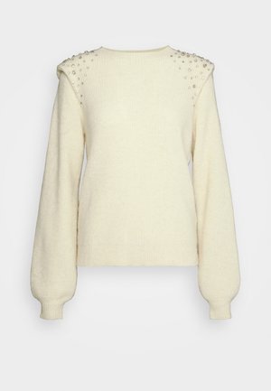 Maglione in maglia color crema con maniche lunghe a sbuffo e decorazioni di perline argento sulle spalle imbottite, polsini e orlo a coste.