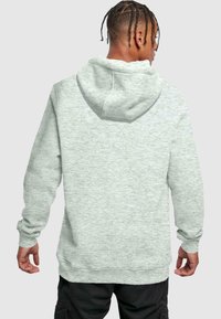 Svetlošedá bavlnená mikina s kapucňou na šnúrku, rebrovanými manžetami a lemom. Má textúrovanú látku a voľný strih.