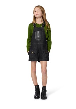 Denim tuinbroeken met verstelbare bandjes, zwarte kleur, voorzien van een leren voorzak met logo en twee voorzakken. Draagt met een groene langemouwen top.