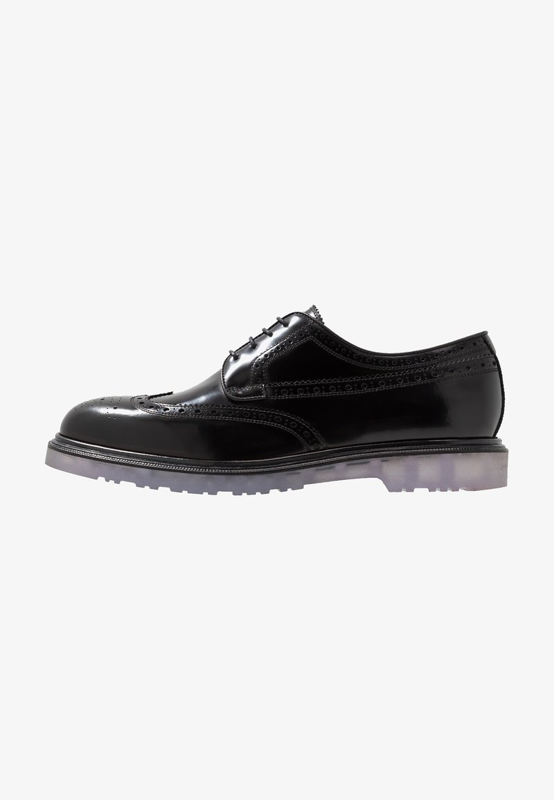 Chaussures en cuir noir à lacets avec détails en brogue, présentant une finition brillante, un capuchon de protection plein et une semelle en caoutchouc translucide.