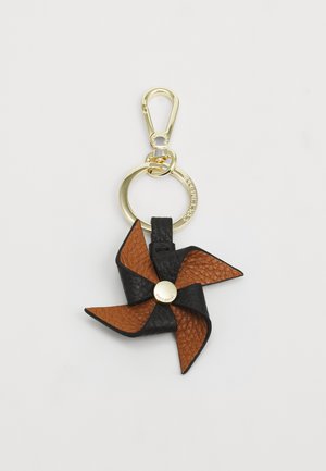 Porte-clés en cuir aux couleurs noire et brune ; design de moulin à vent avec des surfaces texturées et un accent en métal doré sous forme de cercle.