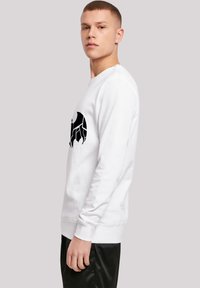 Hvid sweatshirt lavet af blødt stof, med et stort sort abstrakt grafik på forsiden, ribbede manchetter og en klassisk rund halsudskæring.