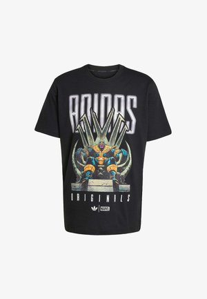 Must musta T-särk, millel on suur graafiline prindiga Thanos, istudes troonil, ja koos "ADIDAS ORIGINALS" tekstiga julgete valgete tähtedega.
