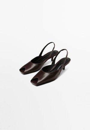 Des talons en cuir bordeaux foncé, à bride arrière, avec un bout ouvert, de forme carrée et un talon modeste. Texture lisse avec des accents minimaux.