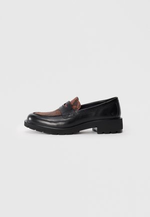 Mocassin en cuir noir avec semelle épaisse et panneau avant texturé marron, présenté sur un fond clair uni, vue de côté.