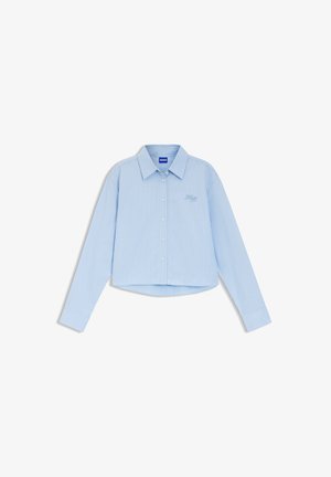Chemise bleu clair à manches longues avec boutons, rayures verticales blanches et petit logo "Hugo" brodé sur la poitrine.
