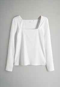 Weißes langärmliges Oberteil mit quadratischem Ausschnitt, gerippter Textur und lockerem Schnitt. Das Material wirkt weich und leicht, ideal zum Schichten geeignet.