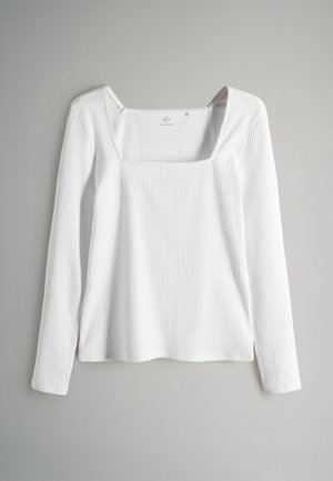 Langærmet hvid top med firkantet udskæring, ribstrikket tekstur og en afslappet pasform. Materialet virker blødt og let, egnet til lag-på-lag.