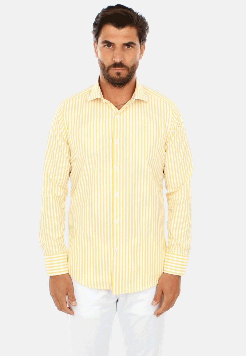 Camicia a maniche lunghe a righe gialle e bianche con chiusura a bottoni, colletto standard e maniche con polsino. Il tessuto sembra morbido e liscio.