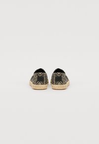 Svart og beige vevde espadrillos med en strukturert overflate, med en naturlig tau såle og subtile logodetaljer på hælen.
