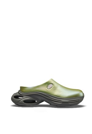 Πράσινο παπούτσι τύπου slip-on με παχιά μαύρη σόλα που διαθέτει κομμάτια με κοψίματα, λείο πάνω μέρος και μικρό οβάλ άνοιγμα κοντά στη φτέρνα.