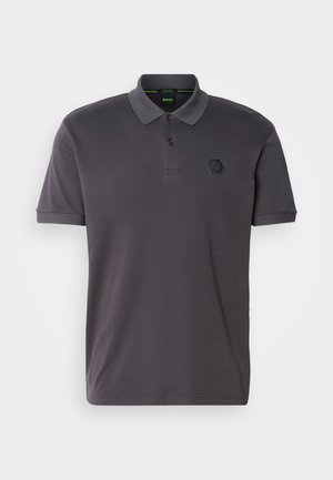 Tumši pelēks polo krekls ar apkakles kakla izgriezumu, īsām piedurknēm, divām pogām un strukturētu sešu stūru logo uz krūtīm. Gluda auduma tekstūra.
