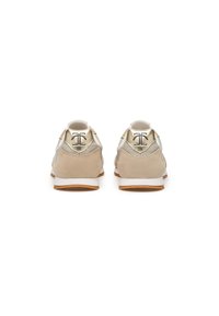 Sneaker beige con tomaia in suede e mesh, dettagli metallici sul tallone e suola in gomma bianca per un'ottima aderenza.