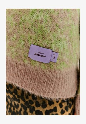 Kootud riided, millel on karvane tekstuur, valgusroheline ja helesinine gradient ning leopardimuster alumises osas. Silt ütleb "Naoko Knitwear."