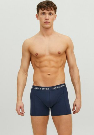 Boxers-briefs bleu marine avec une ceinture élastique de marque. Le tissu semble lisse ; le design présente une coupe ajustée.
