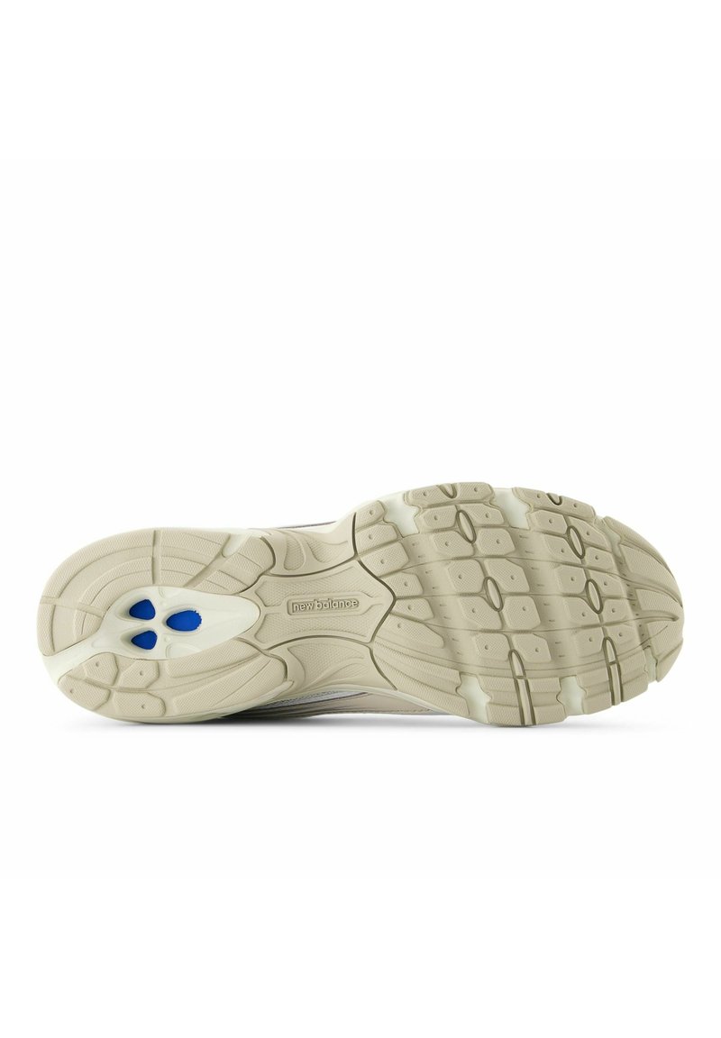 Beige zool van een sportschoen met een gestructureerd rubberen profiel, blauwe accenten en een ontwerp met twee tinten en het merklogo.