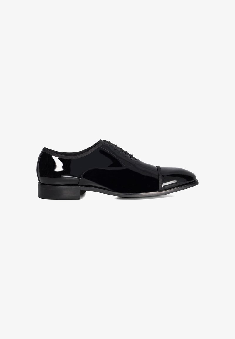 Chaussure habillée en cuir verni noir avec un bout arrondi, six œillets pour les lacets et une finition lisse. Présente un petit talon en caoutchouc noir.