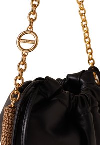 Schwarze Lederhandtasche mit einem gerafften Design, ausgestattet mit einem goldenen Kettenriemen und runden Beschlägen. Ein strukturiertes, tannfarbenes Akzentstück ist am Reißverschluss befestigt.