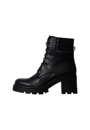 Bottine en cuir noir avec talon bloc épais, lacets à l’avant et panneau élastique côtelé en haut à l’arrière.